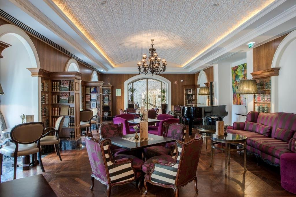Sala de estar do InterContinental Porto – Palacio das Cardosas, an IHG Hotel com mesas e cadeiras.