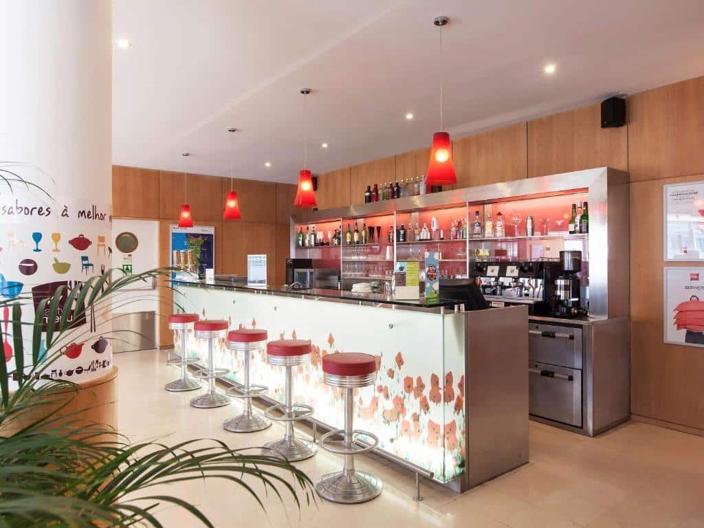 Bar do Hotel ibis Porto Sao Joao balcão do lado esquerdo com bancos em frente ao balcão.