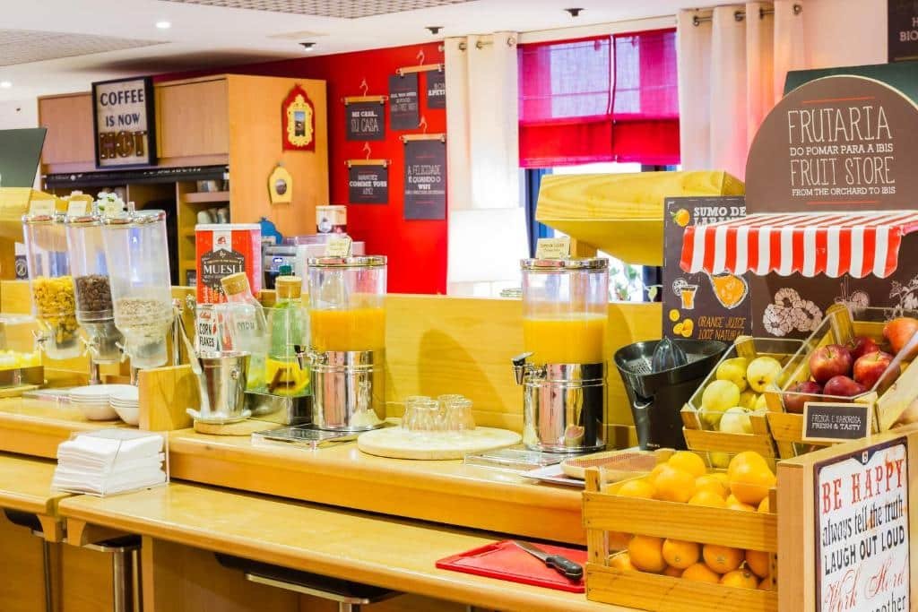 Mesa de café da manhã do ibis Porto Centro São Bento com muitas frutas e sucos.