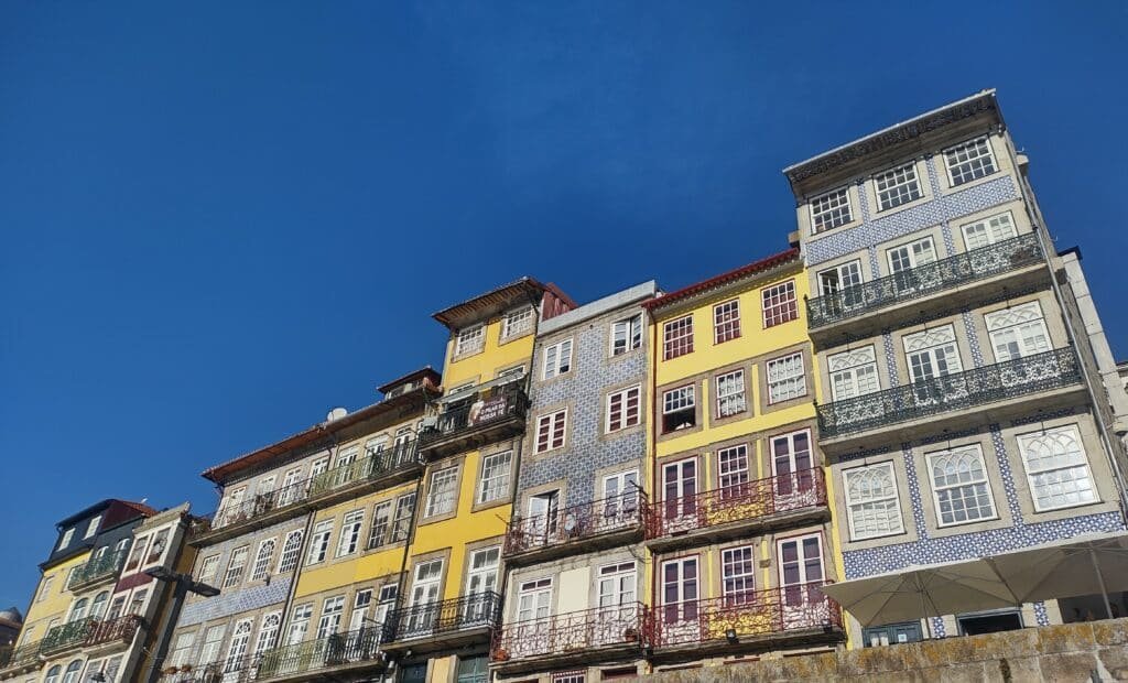 Casinhas coloridas no Cais da Ribeira durante o dia.