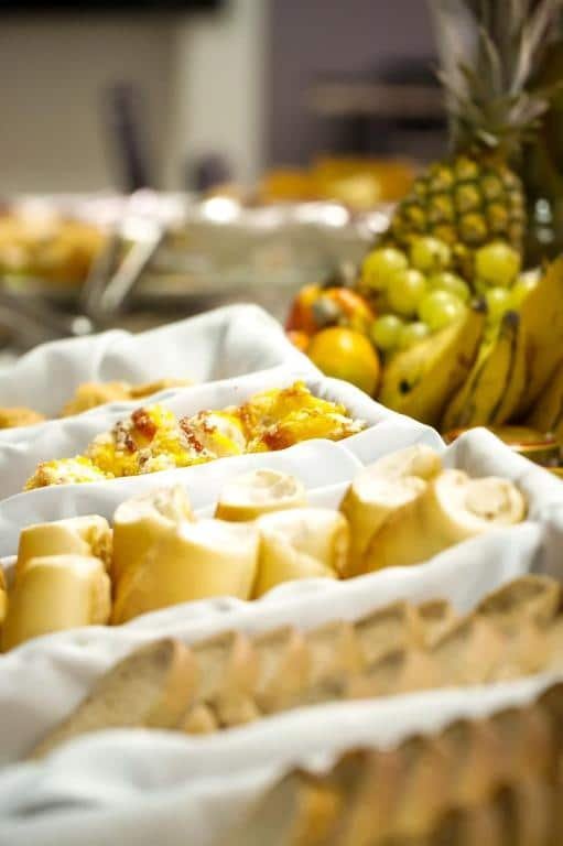 Cestas com toalhas brancas com pães e bolos em café da manhã de hotel.