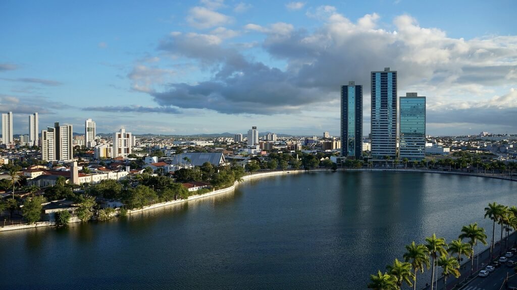 Açude Velho em Campina Grande visto de cima com prédios, casas e árvores em volta.