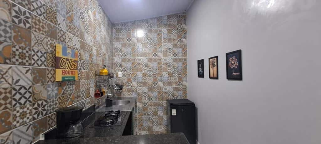 Cozinha do airbnb KITNET vila do Abraão. No canto esquerdo está a bancada com fogão embutido e a pia e já no lado direito há um frigobar.