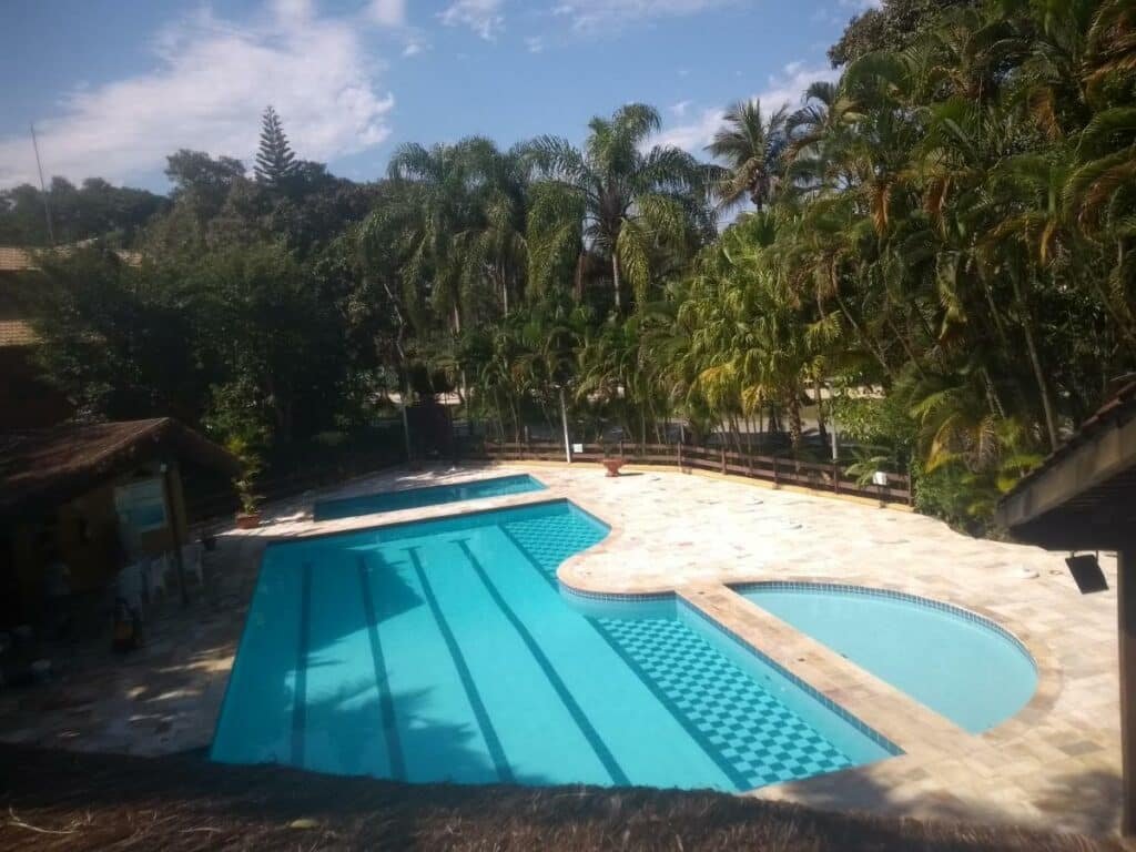 Piscina do STUDIO A RIVIERA - Flat Service 318, cercado por muita natureza e, no deck, algumas espreguiçadeiras