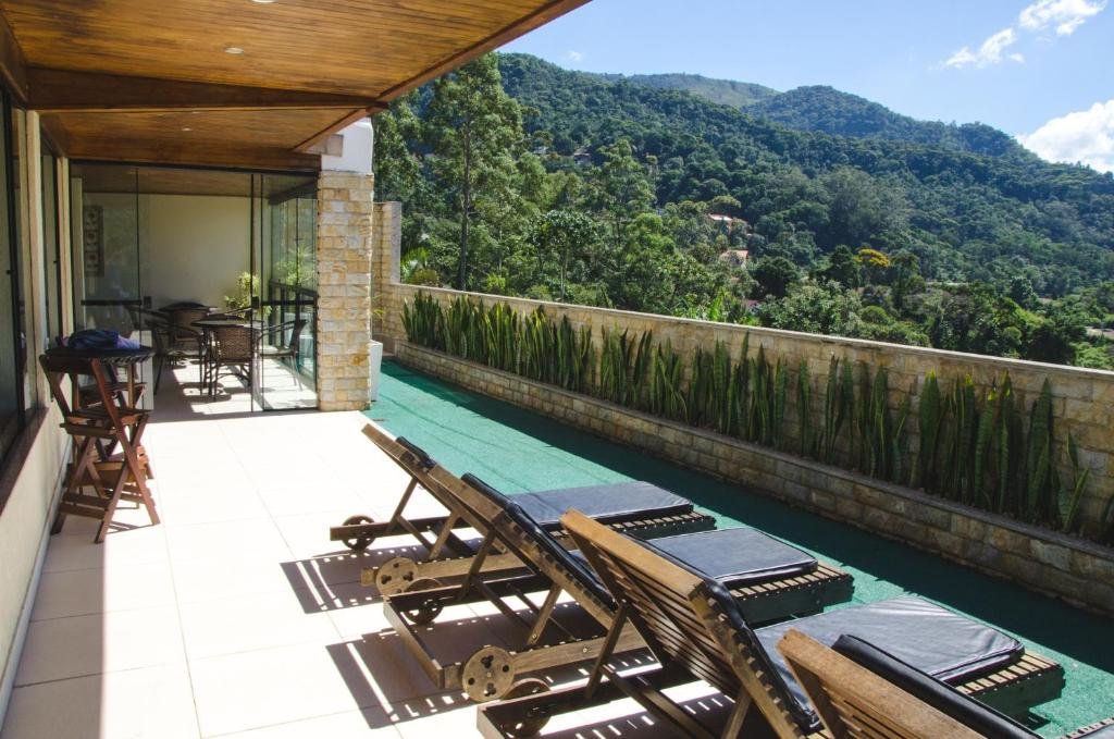 Parte do Hotel Willisau em Teresópolis com cadeiras para tomar sol e vista para as montanhas, ilustrando post pousadas em Teresópolis.