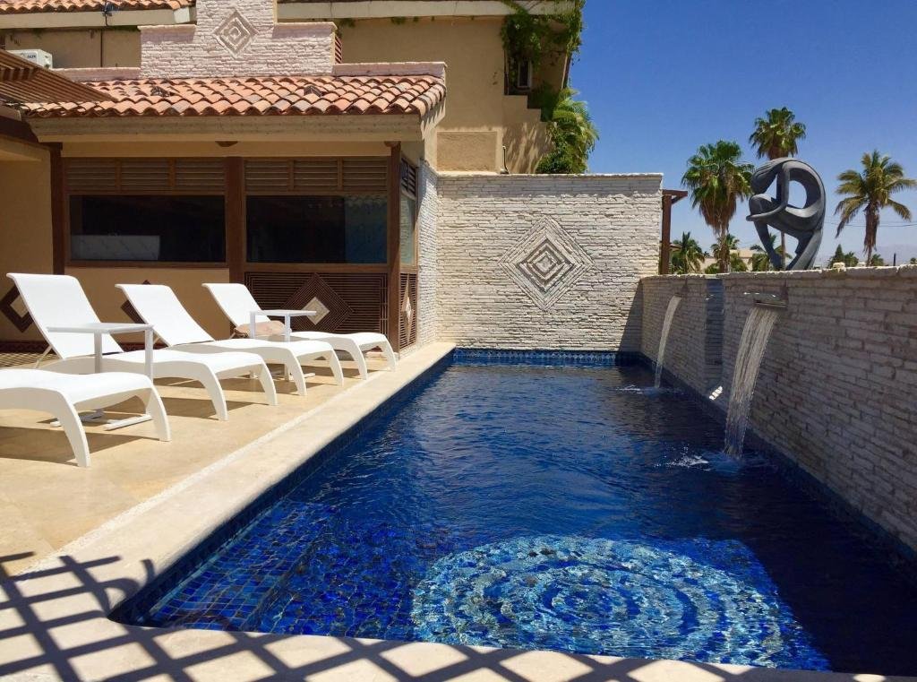 Piscina do Cabo Vista Hotel Adults Only com cadeiras do lado esquerdo. Representa hotéis em Los Cabos