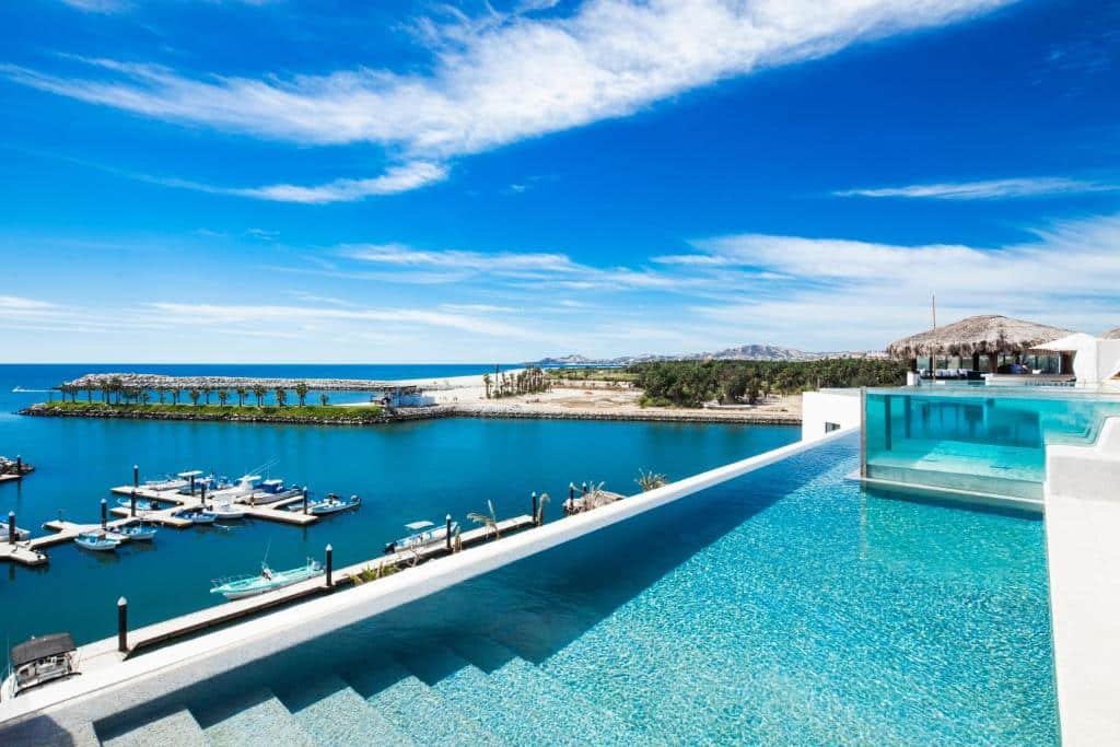 Piscina do Hotel El Ganzo Adults Only com vista para o mar e céu azul.