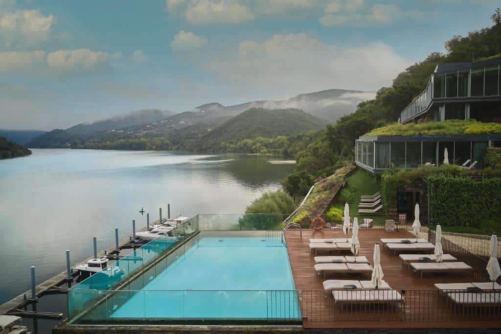 Vista da piscina do Octant Douro durante o dia do lado direito da imagem cadeiras e do lado esquerdo a piscina com vista para o rio Douro.