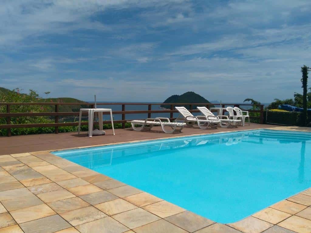 Piscina em Toque Toque Grande Paraíso, com algumas espreguiçadeiras ao redor e uma vista do mar e das ilhotas ao redor