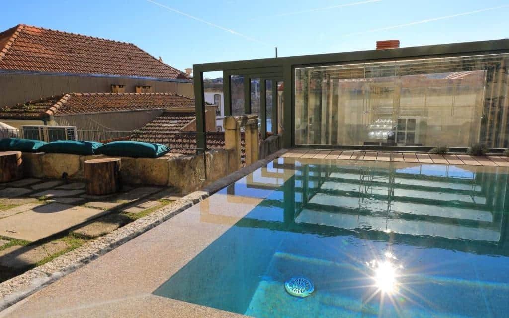 Piscina do Porta Nobre – Exclusive Living Hotel durante o dia do lado direito da imagem.