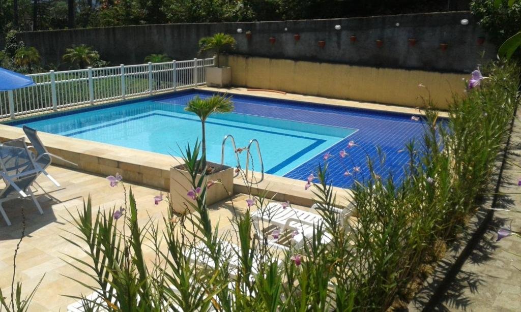 Piscina da pousada Matitaterê em Teresópolis com flores em volta durante o dia.