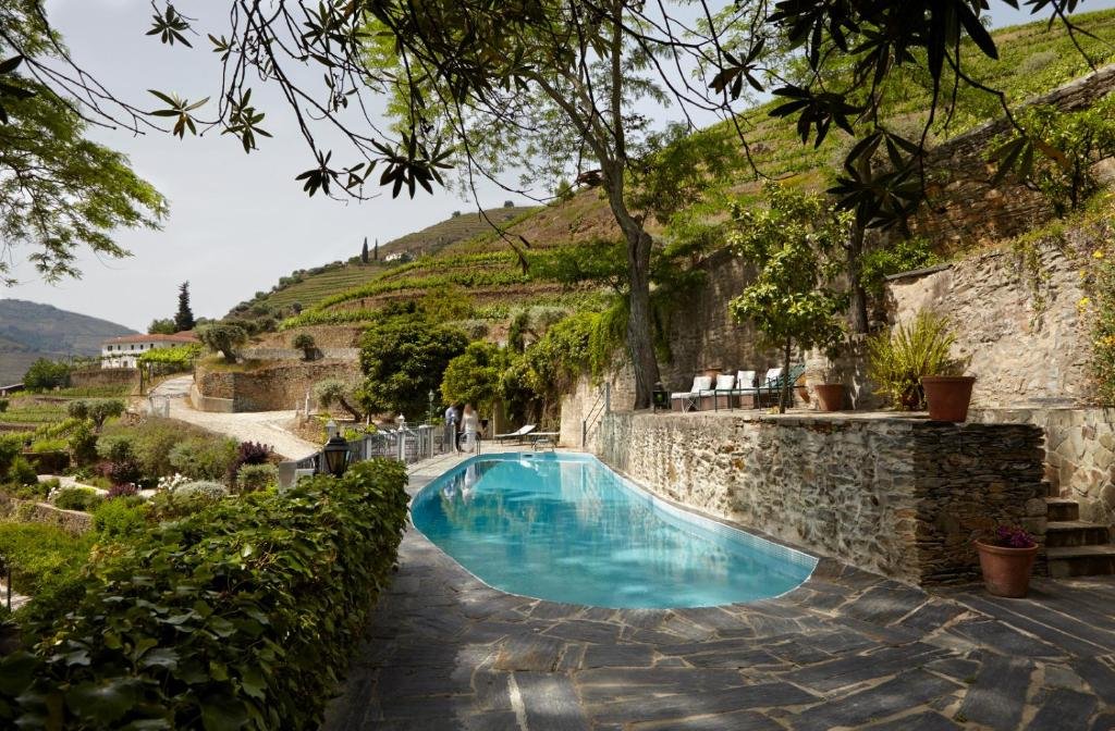 Área da piscina do Quinta de la Rosa durante o dia com piscina no centro.