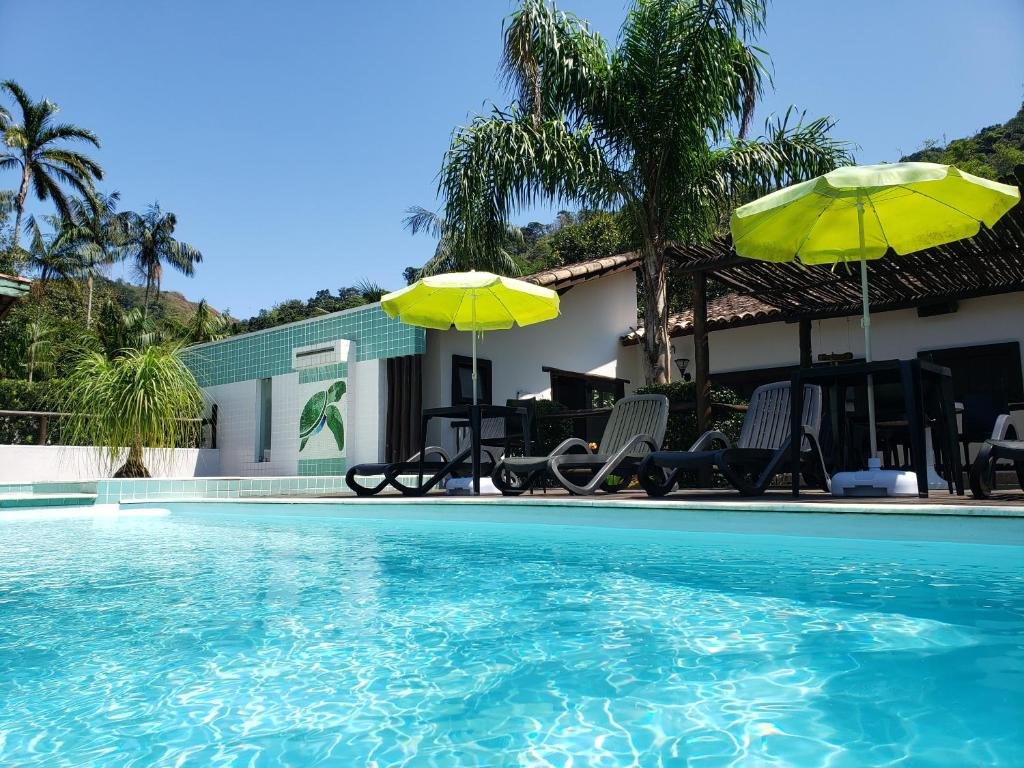 Piscina com cadeiras em Pousada Tartarugas de Paúba.