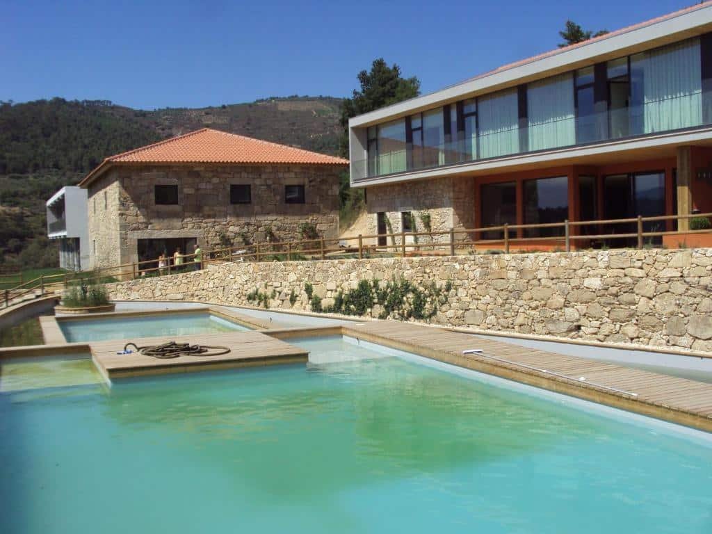 Piscina do lado esquerdo do Douro Cister Hotel Resort e do lado direito a hospedagem.