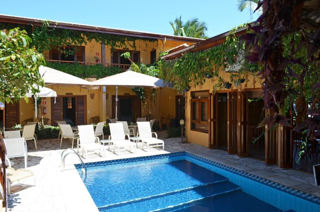 Área com piscina e cadeiras na Pousada Mata Atlântica Juquehy