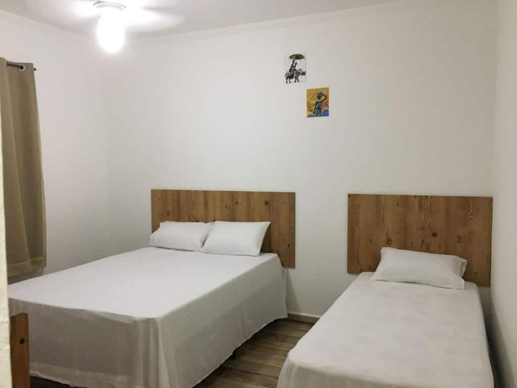 Quarto com uma cama de casal e outra de solteiro da pousada pé na terra, em Guararema