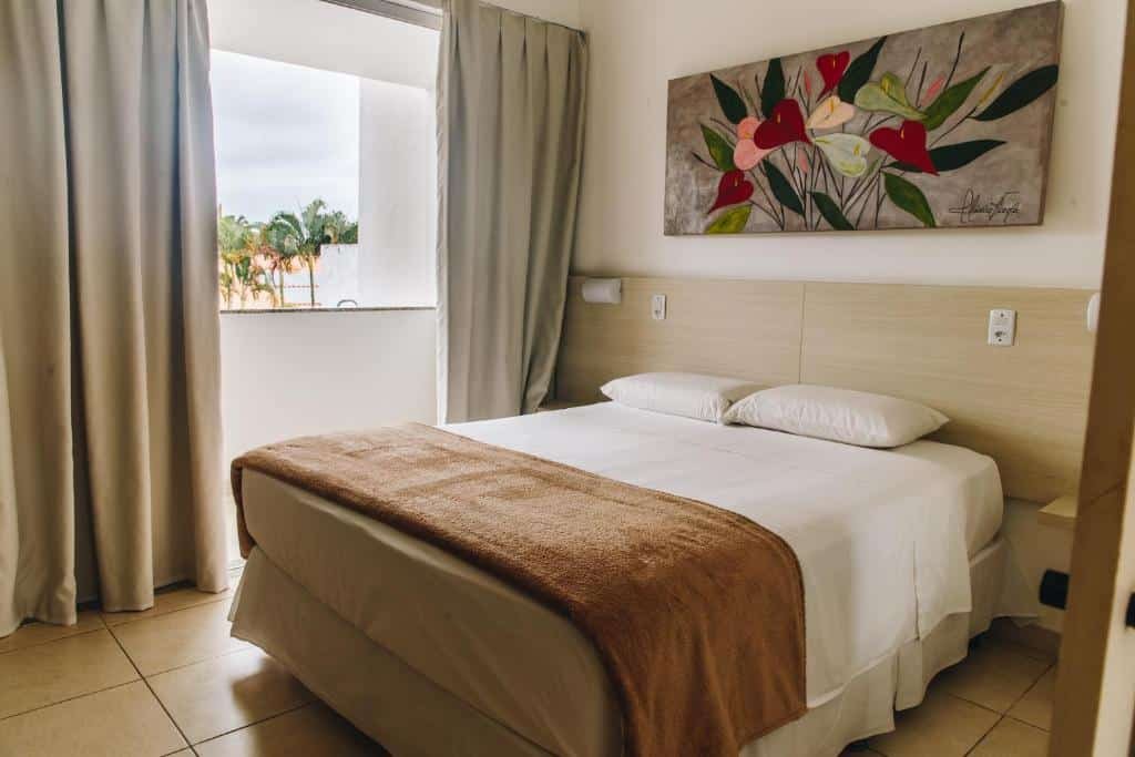 Quarto com cama ampla Jardim Atlântico Beach Resort.