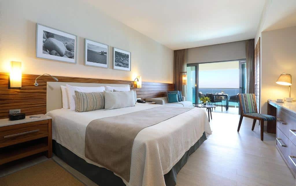 quarto do Emporio Cancun com uma cama de sal, uma área de estar e uma varanda particular