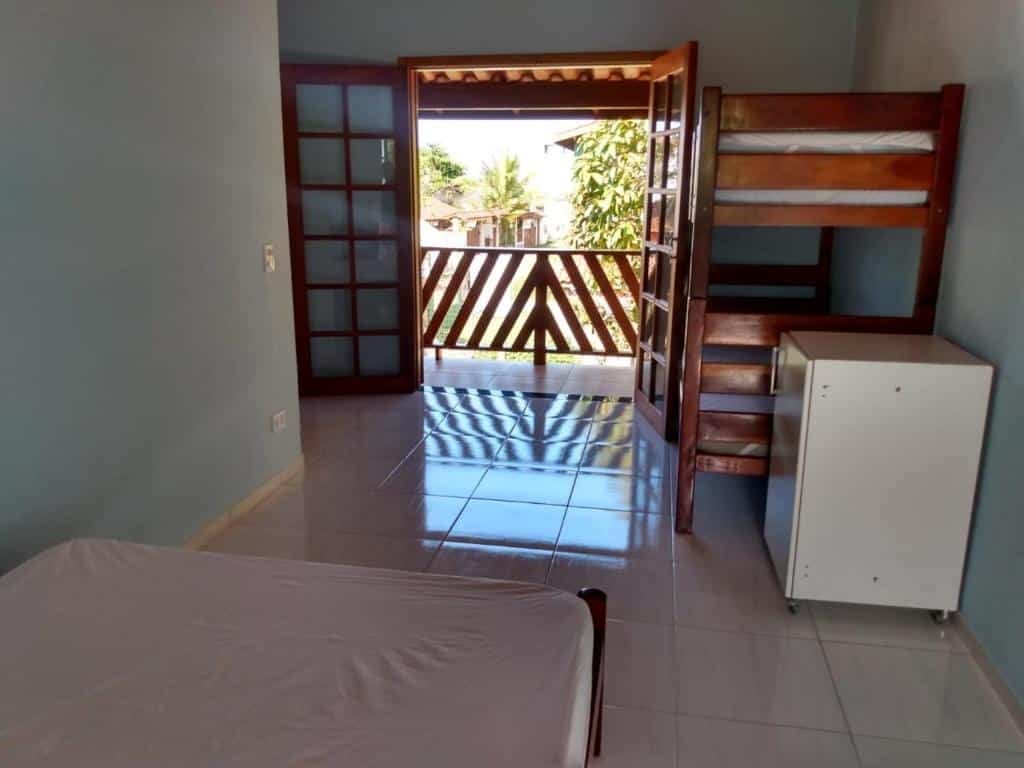 Vista do quarto da Casa na praia do estaleiro com cama de casal e beliche e frigobar.