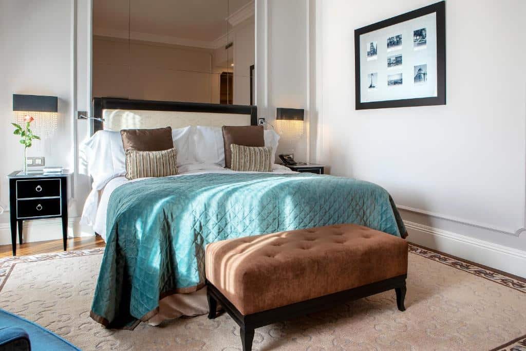 Quarto do InterContinental Porto – Palacio das Cardosas, an IHG Hotel com cama de casal do lado esquerdo, duas cômodas ao lado da cama e uma cômoda no pé da cama. Representa hotéis românticos no Porto.