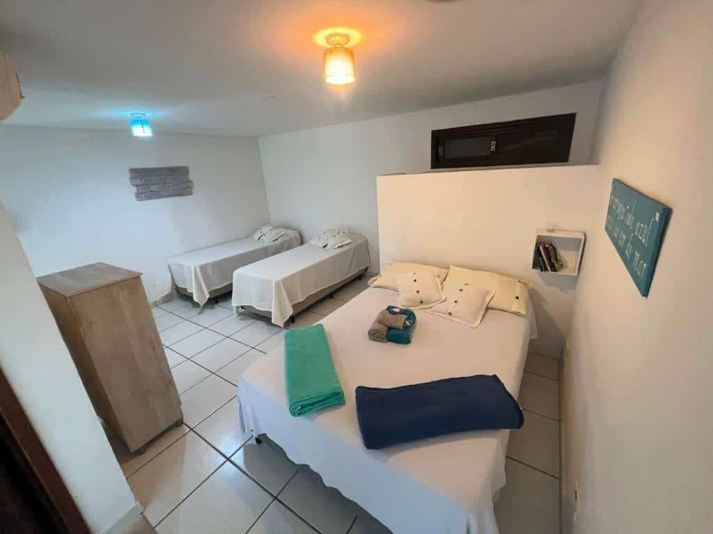 Vista do quarto com cama de casal e duas camas de solteiro no Loft com vista ao mar de frente ao mar.