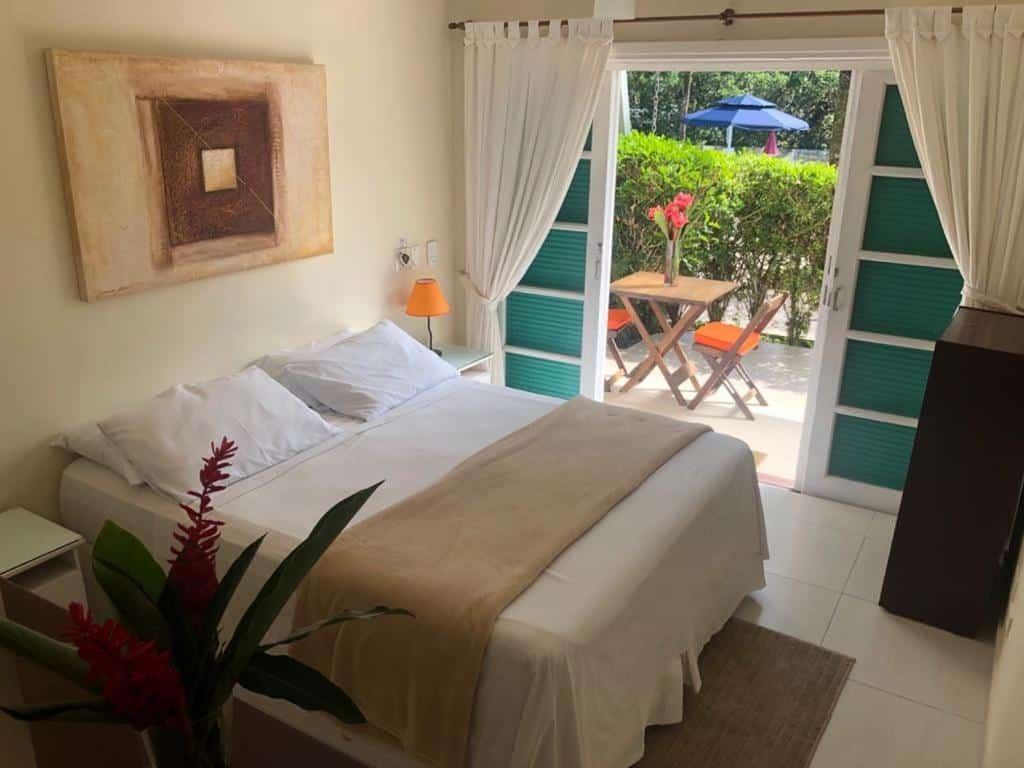 Vista do quarto Pousada Una com cama ampla e varanda na praia da Juréia.
