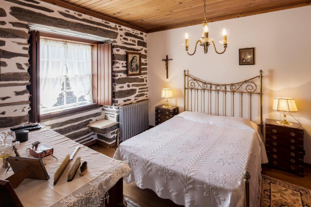 Quarto do Quinta de Marrocos com cama de casal do lado direito da imagem, com uma cômoda em cada lado da cama com luminária.