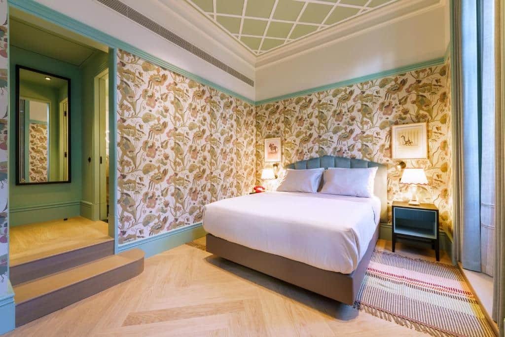 Quarto do The Editory Boulevard Aliados Hotel com cama de casal do lado direito, duas cômodas ao lado da cama com luminária. Representa hotéis românticos no Porto.