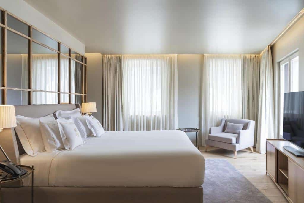 Quarto do Vignette Collection – Casa da Companhia, an IHG Hotel com cama de casal do lado esquerdo, em cada lado da cama uma cômoda com luminária e em frente a cama cômoda com TV. Representa melhores hotéis no Porto.