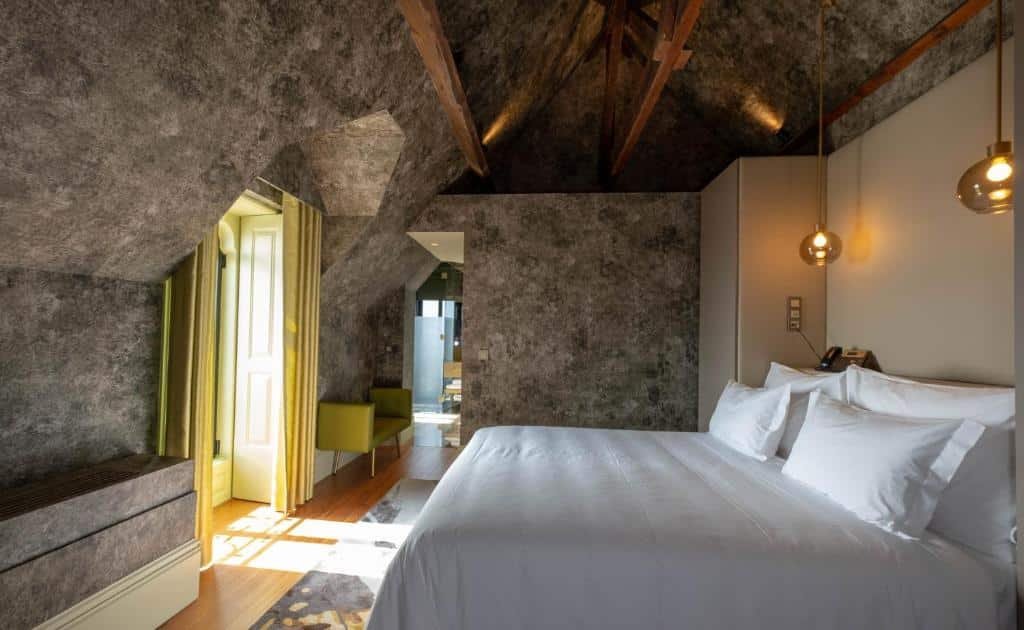 Quarto amplo do Vila Foz Hotel & SPA – member of Design Hotels com cama de casal do lado direito. Representa hotéis românticos no Porto.