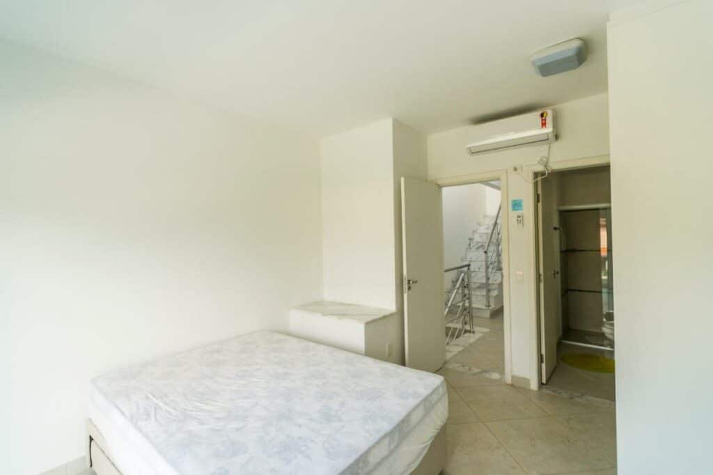 Quarto do Villaggio Juquehy com cama de casal do lado esquerdo da imagem. Representa airbnb na Barra do Sahy.