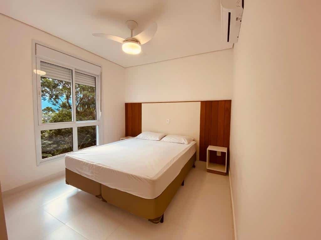 Quarto do Vista Mágica na Praia de Camburizinho com cama de casal no centro do ambiente em cada lado da cama uma cômoda. Representa airbnb em São Sebastião.