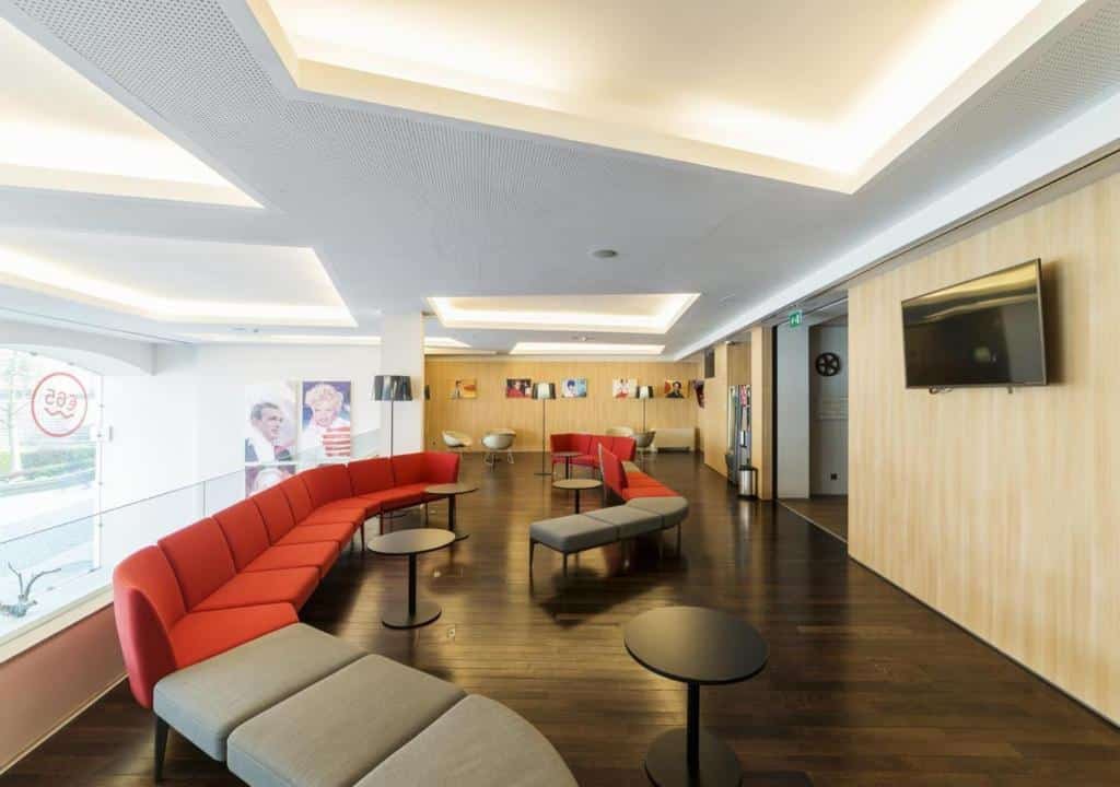 Sala de estar do Moov Hotel Porto Centro com sofá e TV no ambiente.
