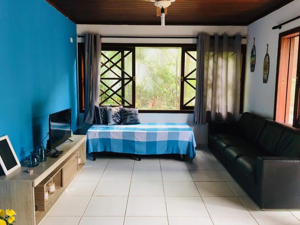 Sala da Casa Maresias Canto do mar - 50m da praia com televisão e sofá.