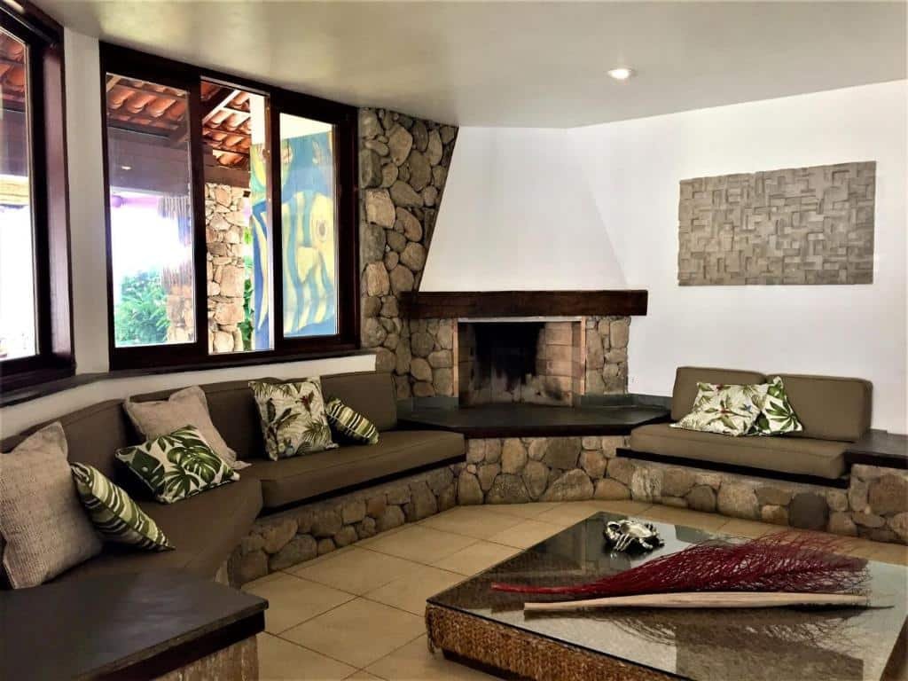 Sala ampla na Casa pé na areia de revista com lareira em Juquehy.