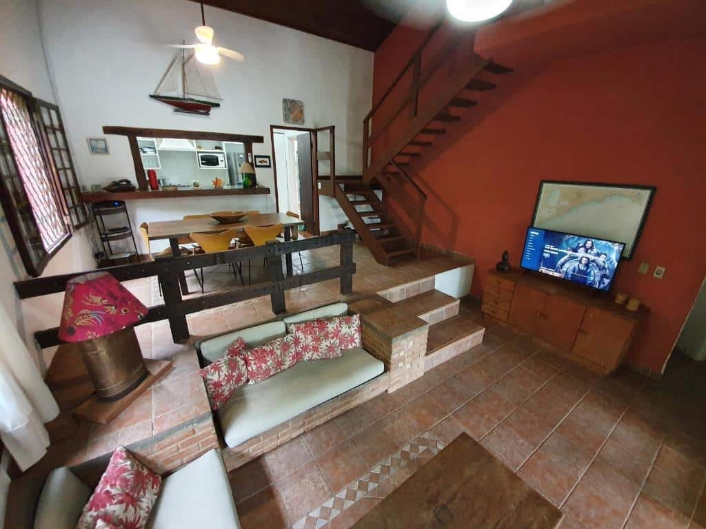 Sala com TV e mesa de jantar na Casa pé na areia em Toque Toque.