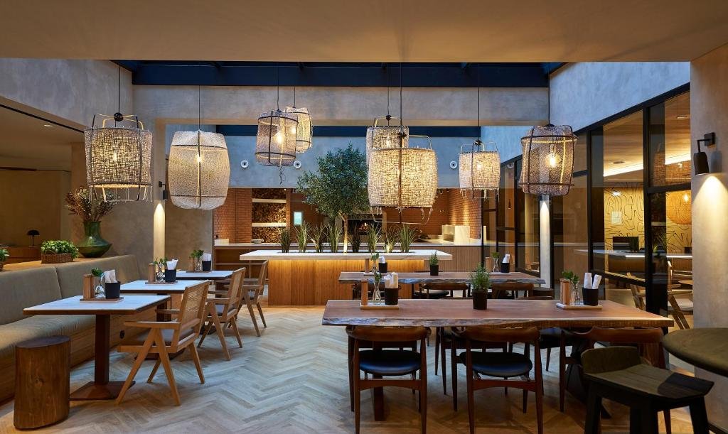 Sala de jantar do PortoBay Teatro com várias mesas e cadeiras.