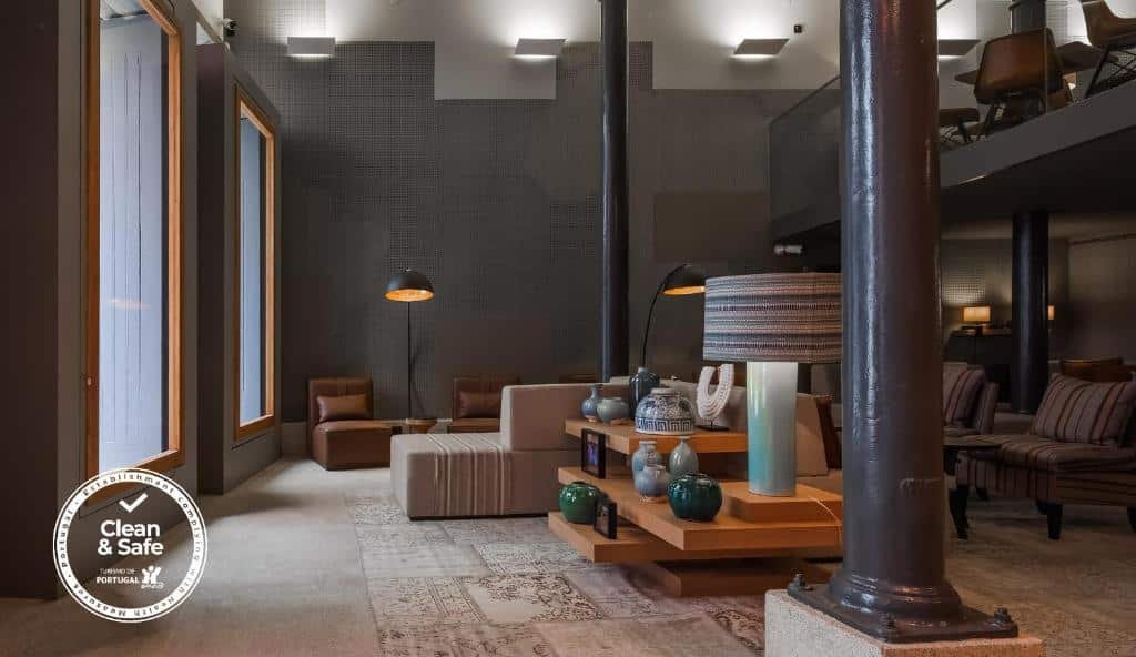 Sala do Descobertas Boutique Hotel Porto com sofás e poltronas.