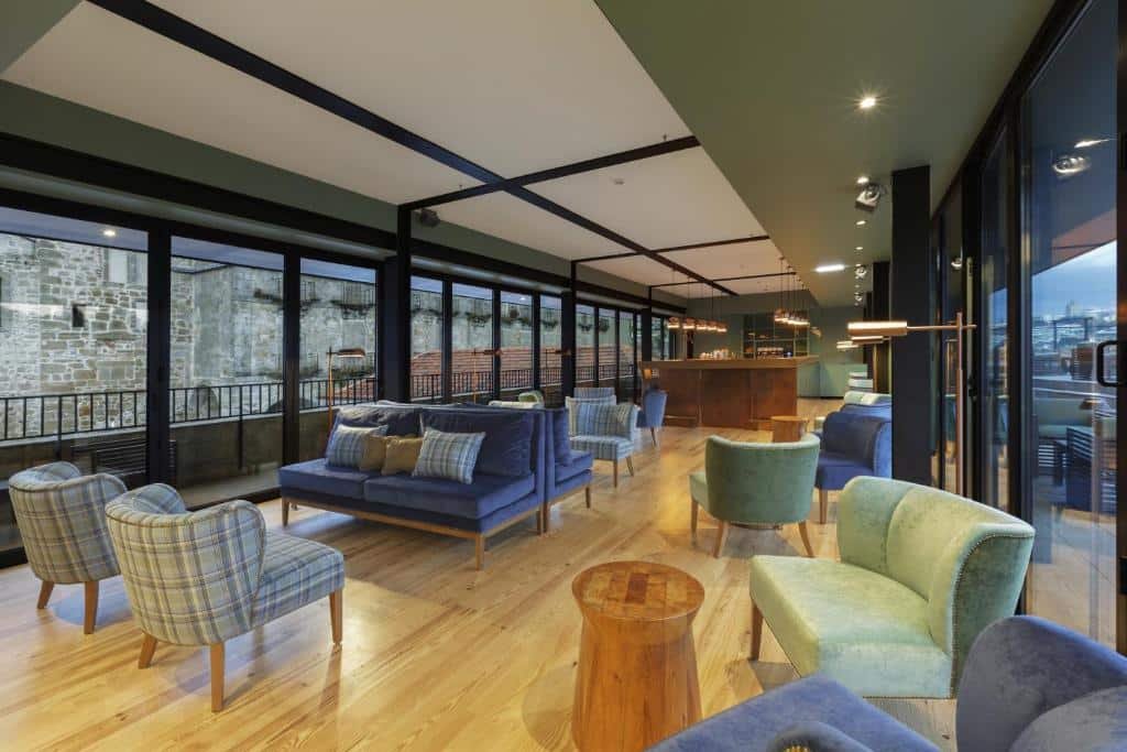 Sala de estar do NEYA Porto Hotel com várias poltronas e sofás no ambiente.