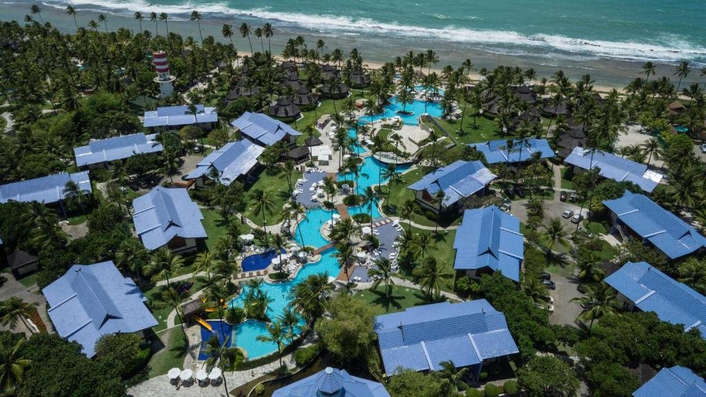 Vista aérea das piscinas do Summerville Resort - All Inclusive de frente para praia e cercado por diversas árvores