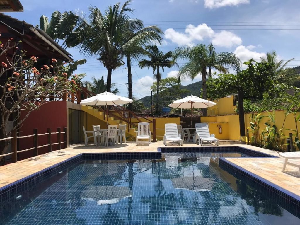 Piscina com espreguiçadeiras na Pousada Vila do Sol Juquehy
